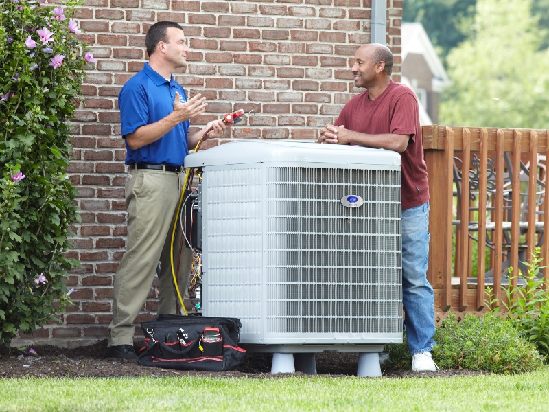 professional and homeowner talking and HVAC unit