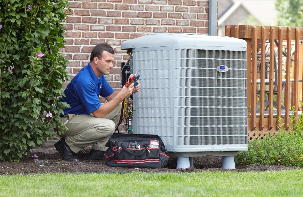 Professional in blue shirt working on HVAC unit